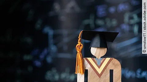 Holzfigur mit Doktorhut