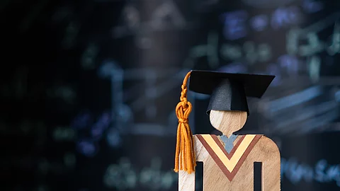 Holzfigur mit Doktorhut