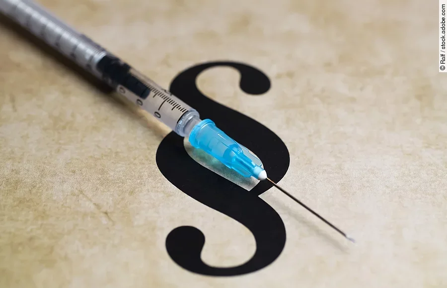 Closeup of paragraph symbol with vaccination syringe - mandatory
