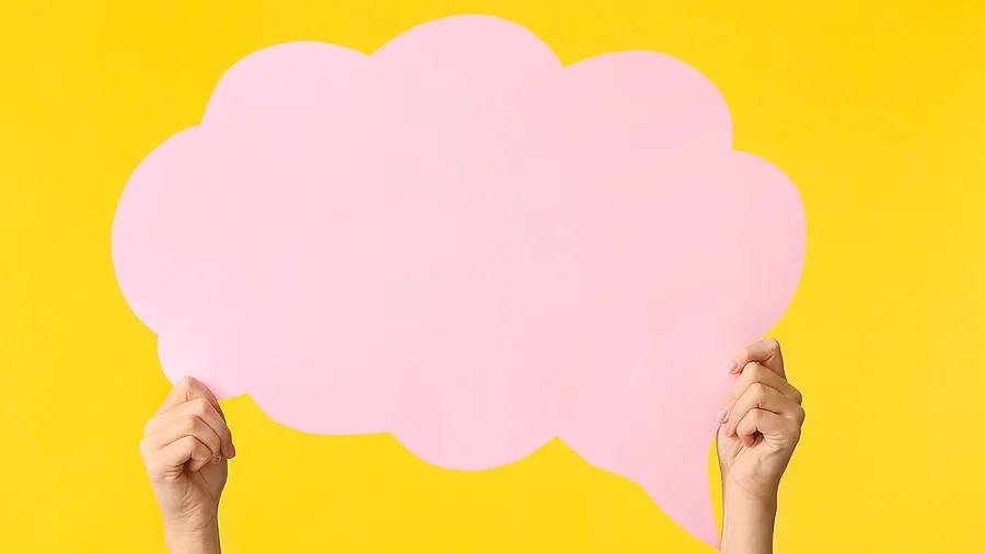 Weibliche Hände mit leerer Sprechblase auf farbigem Hintergrund Weibliche Hände mit leerer Sprechblase auf farbigem Hintergrund. Die Sprechblase ist pink und der Hintergrund gelb.