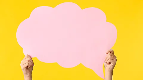 Weibliche Hände mit leerer Sprechblase auf farbigem Hintergrund. Die Sprechblase ist pink und der Hintergrund gelb.