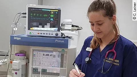 Corinne Leiner bearbeitet das Narkoseprotokoll für die nächste OP. Neben ihr steht das Inhalationsnarkosegerät mit Monitor.