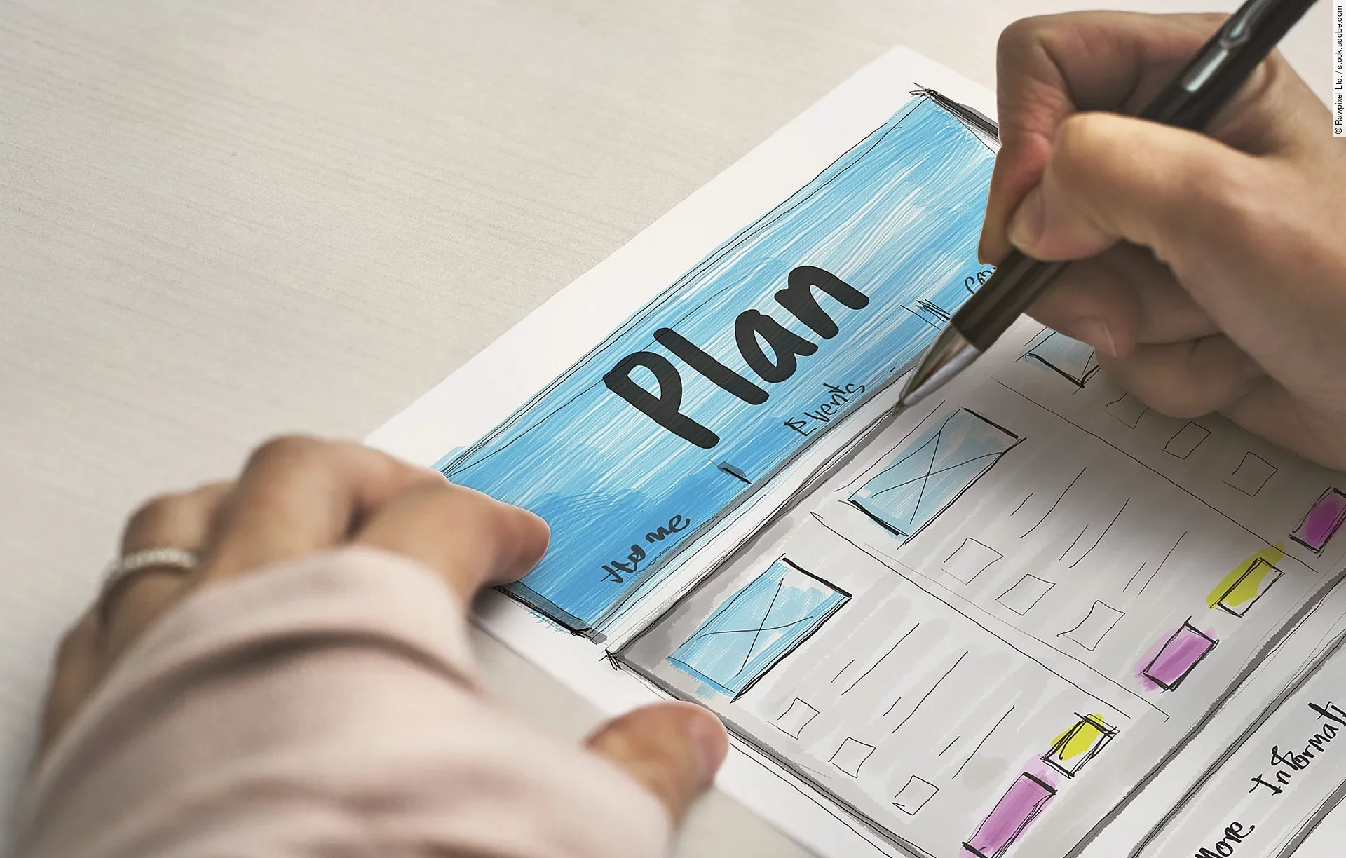 Ein Planzettel liegt im Fokus des Bildes, darauf schreibt eine Person mit Stift..