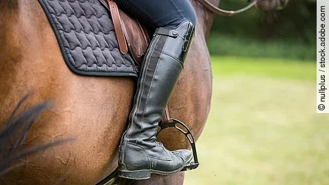 Young Woman Riding Her Horse Nahaufnahme von einer reitenden Person.
