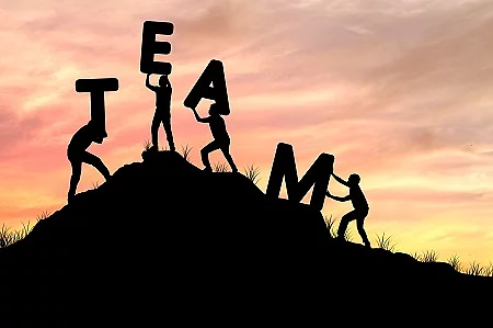 silhouette team work of men helping and lifting word, concept as