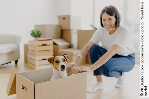 Frau mit ihrem Hund in neuer Wohnung