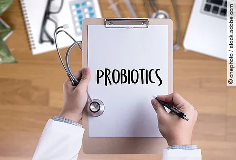 Eine Person hält ein Klemmbrett in der Hand. Auf dem Klemmbrett ist eine Zettel mit der Aufschrift: Probiotics.