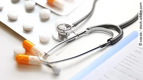 Auf einem Tische liegen verschiedene Medikamente und ein Stethoskop.