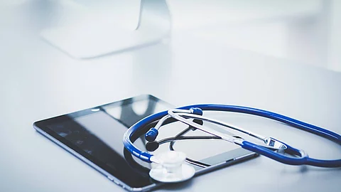 Medical equipment: blue stethoscope and tablet on white backgrou