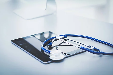 Medical equipment: blue stethoscope and tablet on white backgrou