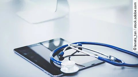 Medical equipment: blue stethoscope and tablet on white backgrou