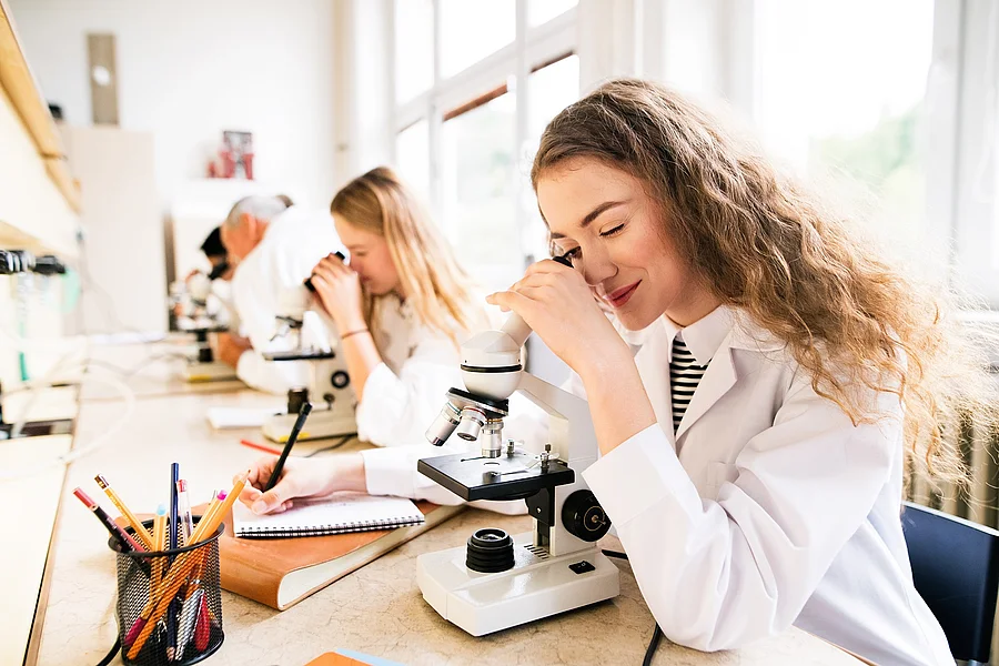 Studenten mikroskopieren in der Universität.