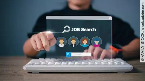 Ein Person sitzt an einem braunen Holztisch und vor ihr liegt eine weiße Tastatur. Ihre linke Hand liegt auf der Tastatur und die rechte Hand zeigt mit einem Zeigefinger nach vorne. Vor der Person ist eine digitale Jobsuche als Hologramm. Auf die Jobsuche zeigt der Zeigefinger. Die Person trägt ein schwarzes Oberteil und eine Smartwacht am Handgelenk. Die Person ist nicht identifizierbar, da das Bild nur bis zu den Schultern reicht. 