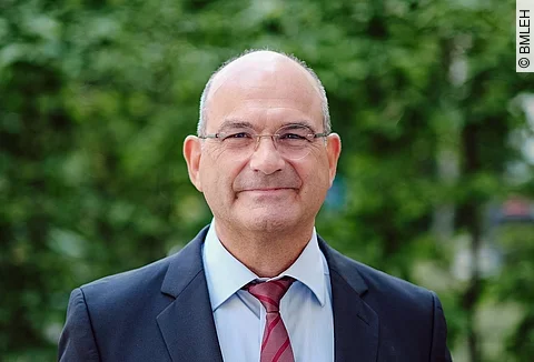 Portrait von Prof. Dr. Dr. Markus Schick. Er schaut freundlich in die Kamera und trägt einen Anzug. 