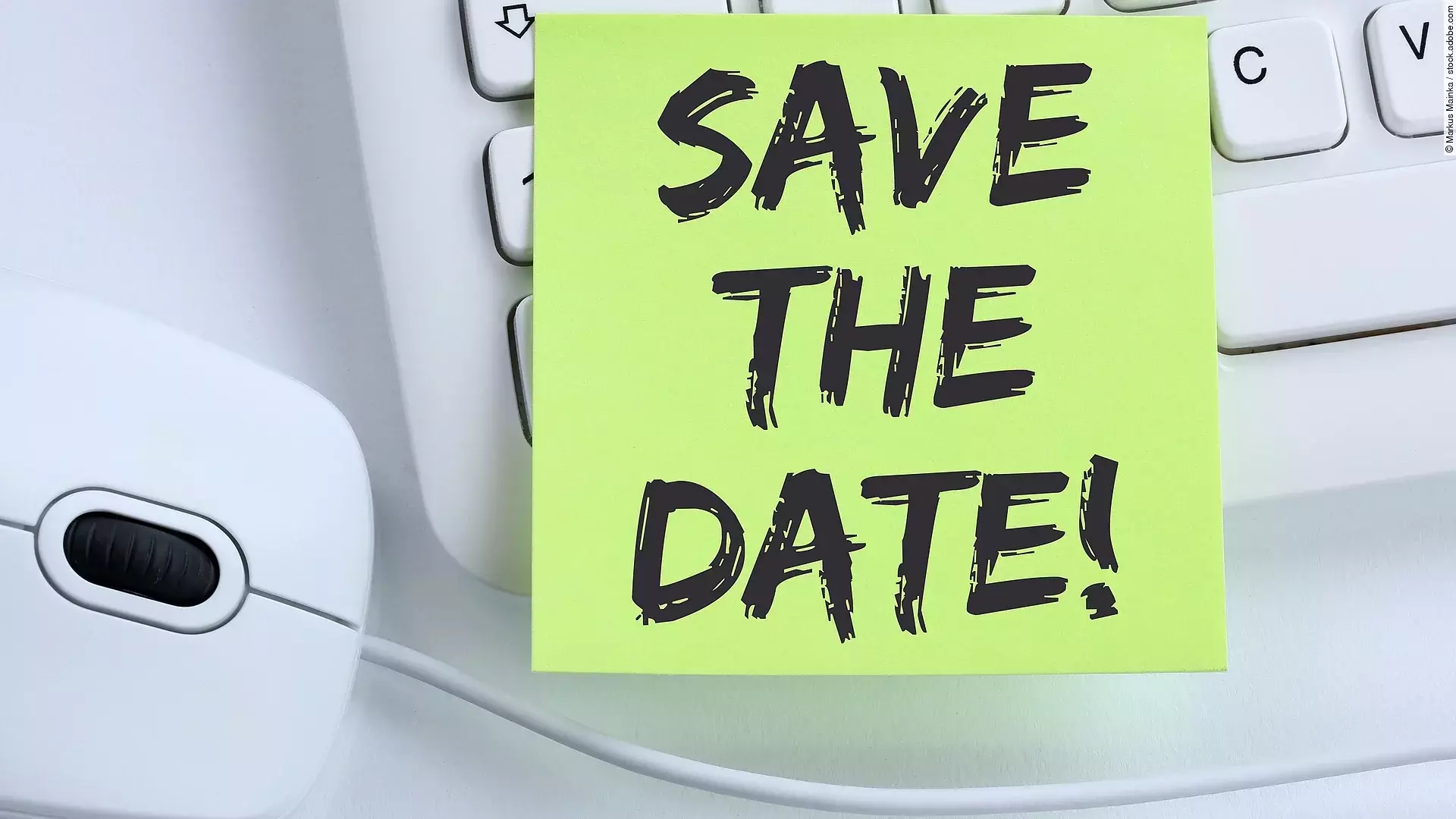 Ein Save the Date Zettel liegt auf einer weißen Tastatur neben einer weißen Computermaus.