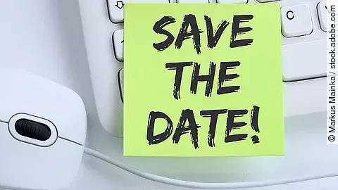 Ein Save the Date Zettel liegt auf einer weißen Tastatur neben einer weißen Computermaus.