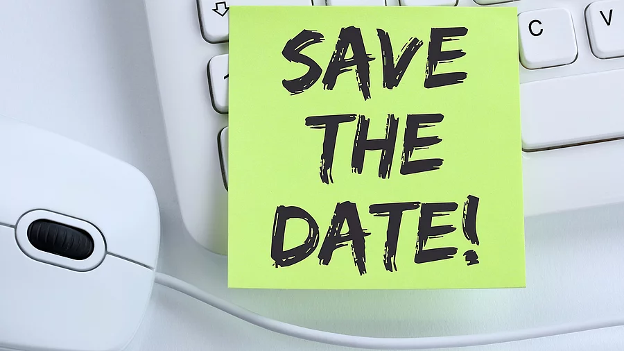 Ein Save the Date Zettel liegt auf einer weißen Tastatur neben einer weißen Computermaus. Ein Save the Date Zettel liegt auf einer weißen Tastatur neben einer weißen Computermaus.