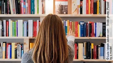 Frau am Bücherregal