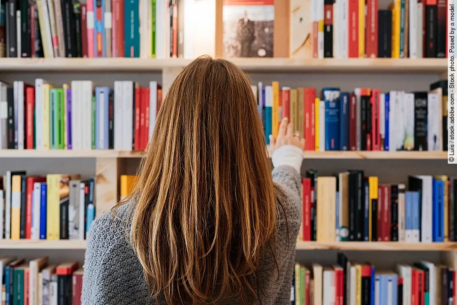 Frau am Bücherregal
