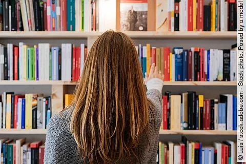 Frau am Bücherregal