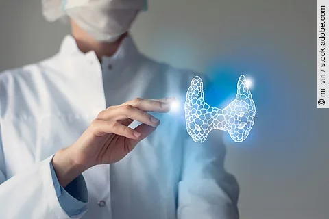 Arzt streckt seine Hand nach 3D-Illustration einer Schilddrüse aus.