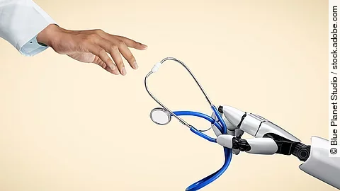 Hand in Arztkittel greift nach Roboterhand mit Stethoskop. 
