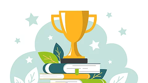 Golden trophy cup standing on the book stack vector isolated.