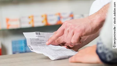 Apotheker erklärt einem Kunden einen Beipackzettel.