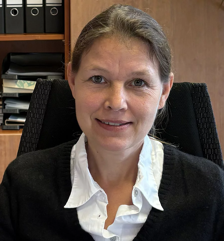 Aufnahme von Frau Prof. Dr. Strube. Sie sitzt in einem Büro und schaut freundlich in die Kamera. Ihre Haare sind zusammengebunden 