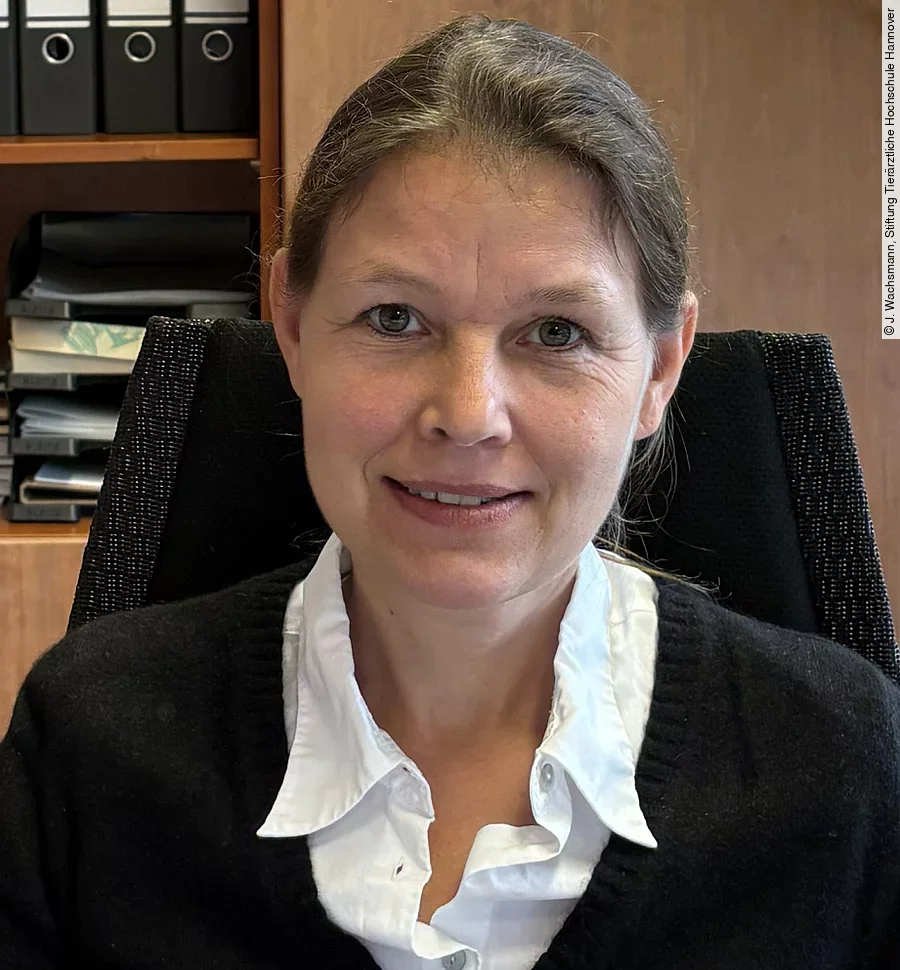 Aufnahme von Frau Prof. Dr. Strube. Sie sitzt in einem Büro und schaut freundlich in die Kamera. Ihre Haare sind zusammengebunden