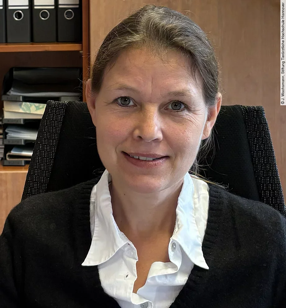 Aufnahme von Frau Prof. Dr. Strube. Sie sitzt in einem Büro und schaut freundlich in die Kamera. Ihre Haare sind zusammengebunden 