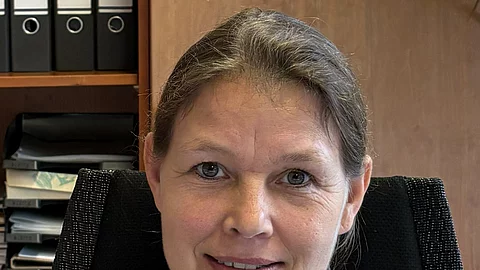 Aufnahme von Frau Prof. Dr. Strube. Sie sitzt in einem Büro und schaut freundlich in die Kamera. Ihre Haare sind zusammengebunden 