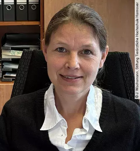 Aufnahme von Frau Prof. Dr. Strube. Sie sitzt in einem Büro und schaut freundlich in die Kamera. Ihre Haare sind zusammengebunden 