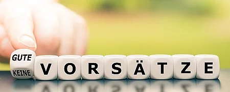 Hand dreht einen Würfel und ändert den Ausdruck "keine Vorsät