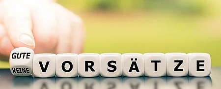 Hand dreht einen Würfel und ändert den Ausdruck "keine Vorsät