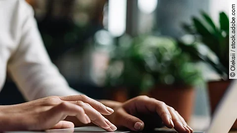 Eine Person sitzt an einem Schreibtisch.