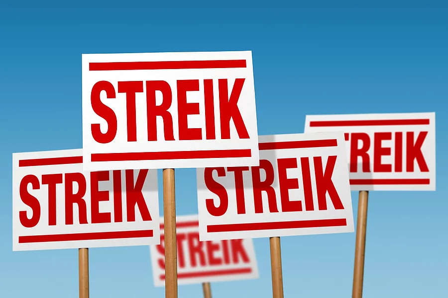 Fünf Schilder mit roter Aufschrift "Streik". 