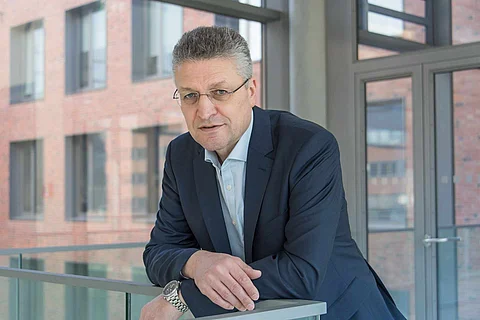 Personenbild von Lothar Wieler an einem Geländer angelehnt.