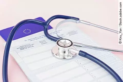 Ein EU-Heimtierausweis und ein Stethoskop liegen auf einem Tisch.