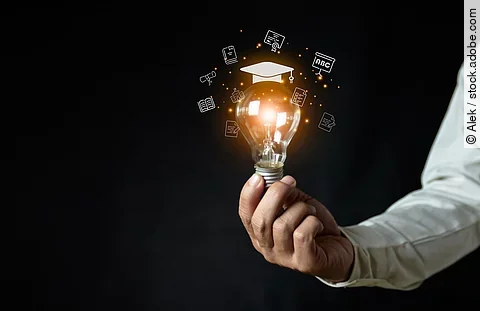 a man holding a light bulb showing his graduation cap internet e