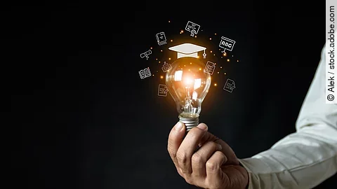 a man holding a light bulb showing his graduation cap internet e
