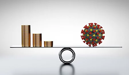 Coins, money and COVID-19 on scale. Concepts of economics against coronavirus
