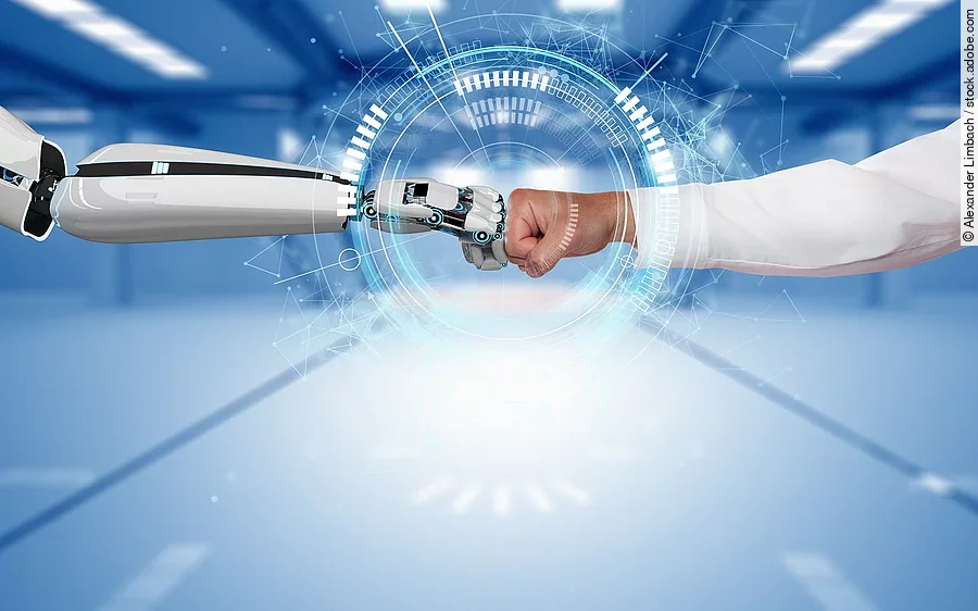 Ein Roboterhand und eine Hand von einer Person berühren sich mit geballten Händen.