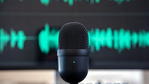 Black condenser microphone, blur turquoise waveform background.