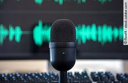 Black condenser microphone, blur turquoise waveform background.