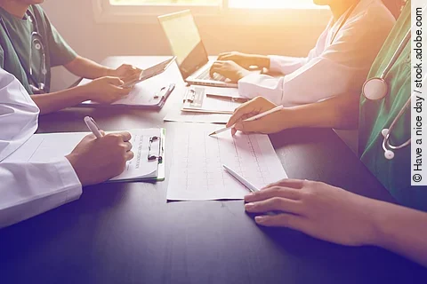 An einem Tisch sitzen vier Personen.