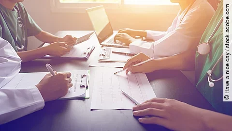 An einem Tisch sitzen vier Personen.