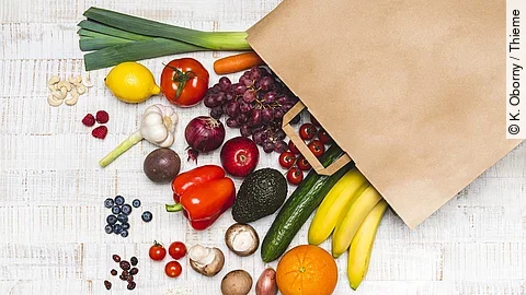 Lebensmittel liegen vor einer Papiertüte ausgebreitet.