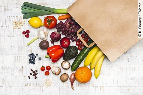 Lebensmittel liegen vor einer Papiertüte ausgebreitet.