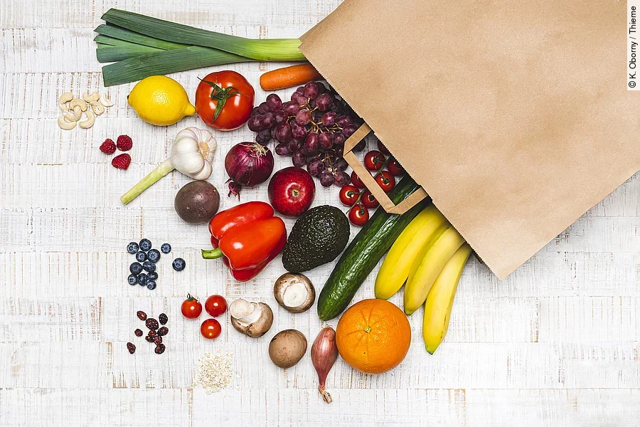 Lebensmittel liegen vor einer Papiertüte ausgebreitet.